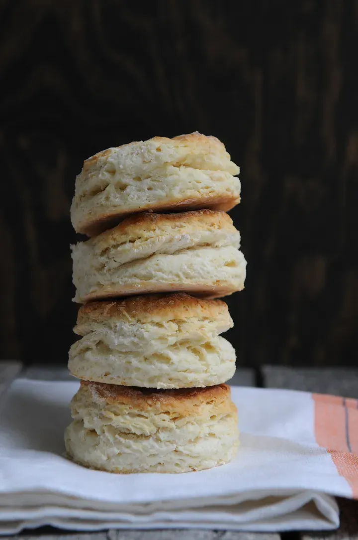 Four biscuits stacked on a cloth napkin